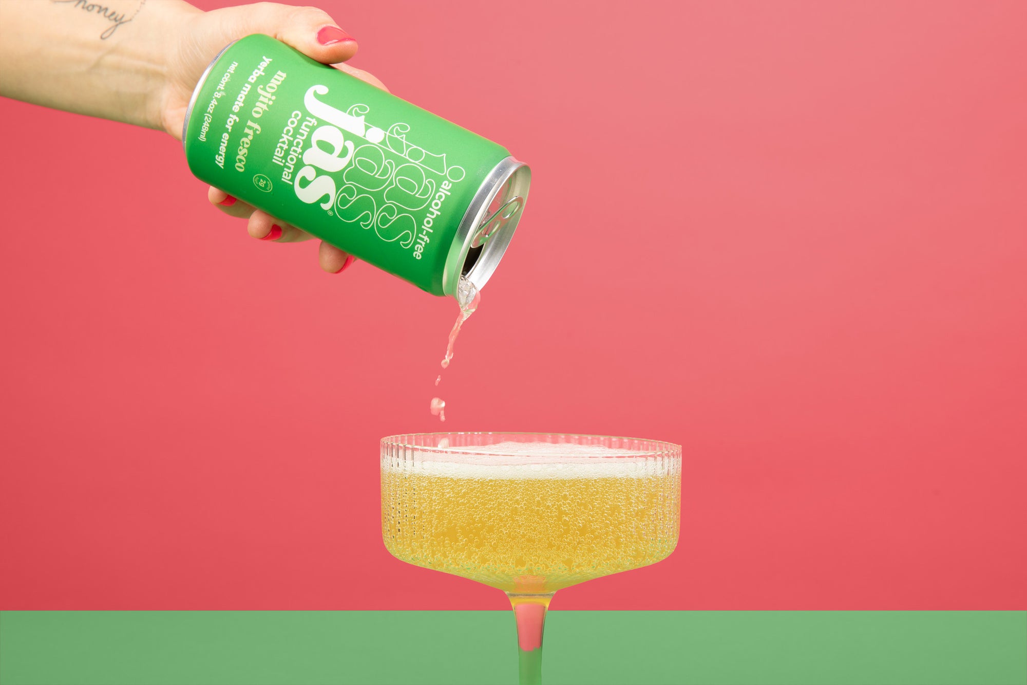 Woman pouring JAS Mojito Fresco into coupe